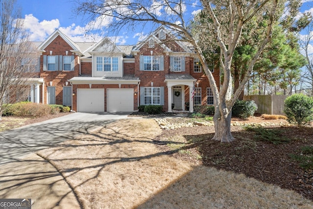 view of front of home with an attached garage, fence, concrete driveway, and brick siding