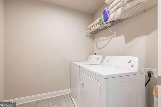 washroom featuring laundry area, light tile patterned flooring, independent washer and dryer, and baseboards