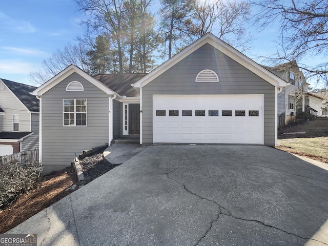 ranch-style home with a garage and aphalt driveway