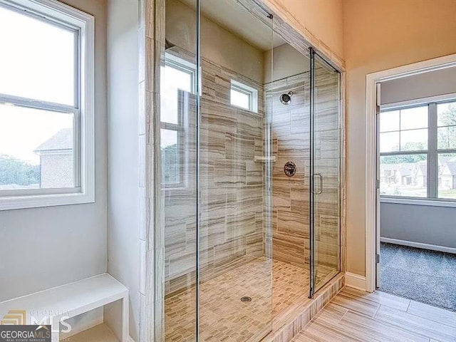 bathroom with a stall shower and baseboards