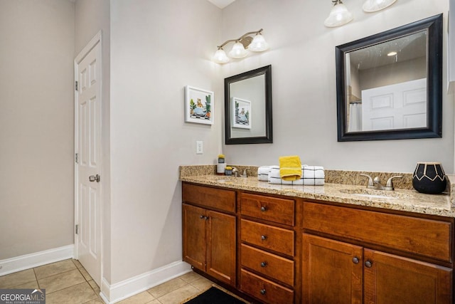 full bathroom featuring double vanity, baseboards, a sink, and tile patterned floors