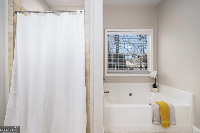 bathroom with a garden tub and a shower with shower curtain