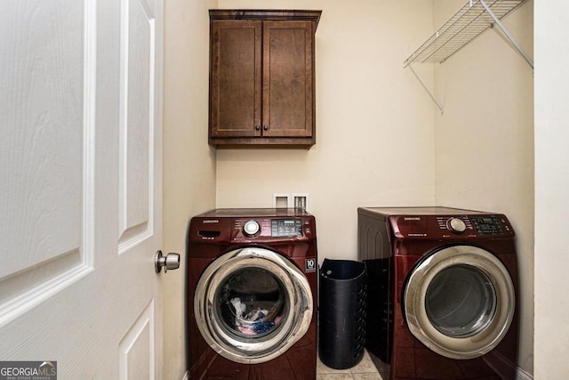 washroom with tile patterned flooring, cabinet space, and washer and clothes dryer