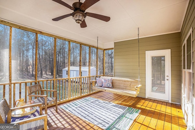 unfurnished sunroom featuring a ceiling fan