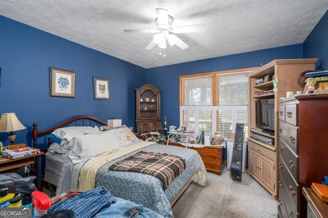 bedroom featuring a ceiling fan, a textured ceiling, and light colored carpet