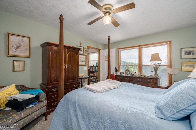 bedroom with ceiling fan and a textured ceiling