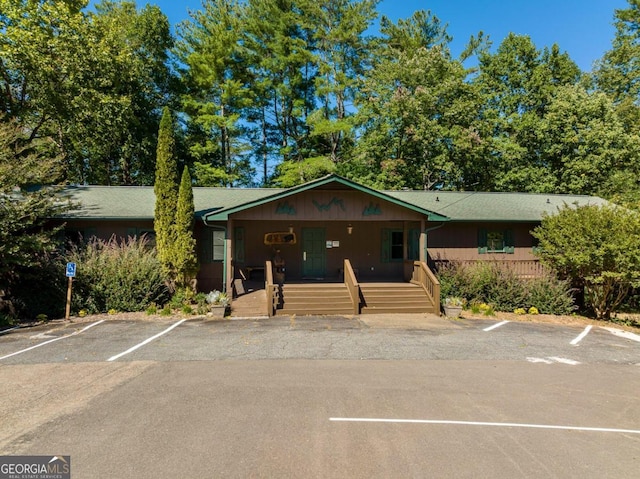 ranch-style home featuring uncovered parking and a porch