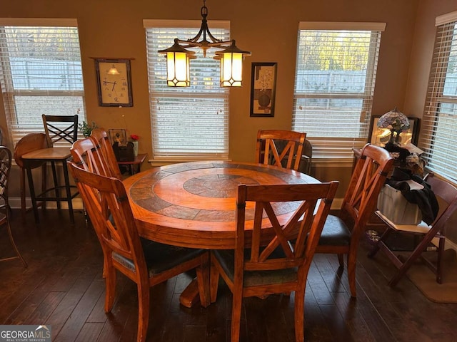 dining room featuring dark wood-style flooring and a healthy amount of sunlight