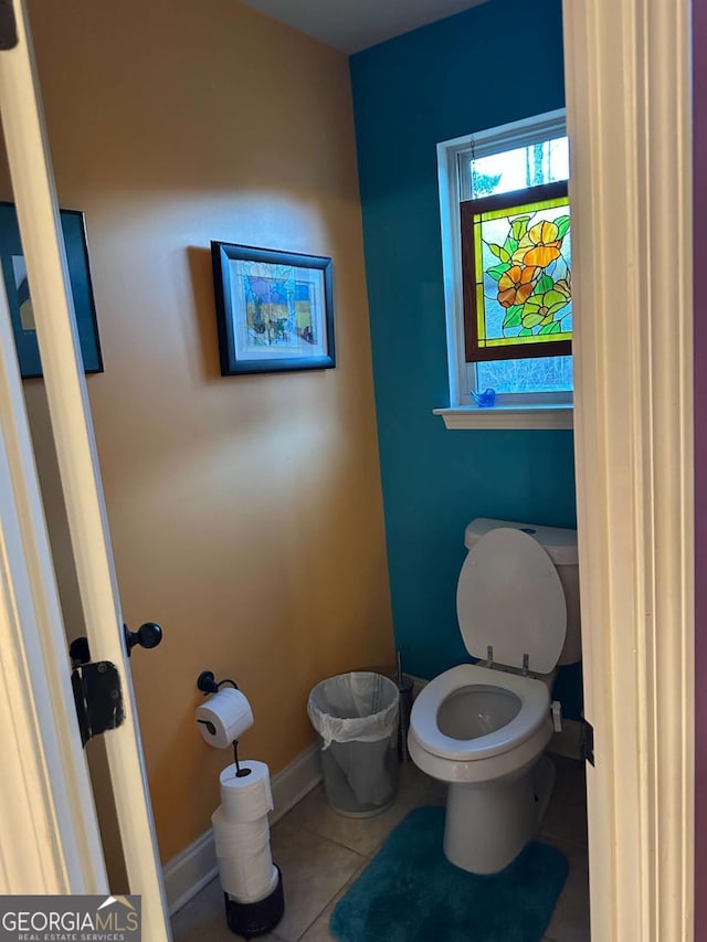 bathroom with tile patterned flooring, toilet, and baseboards