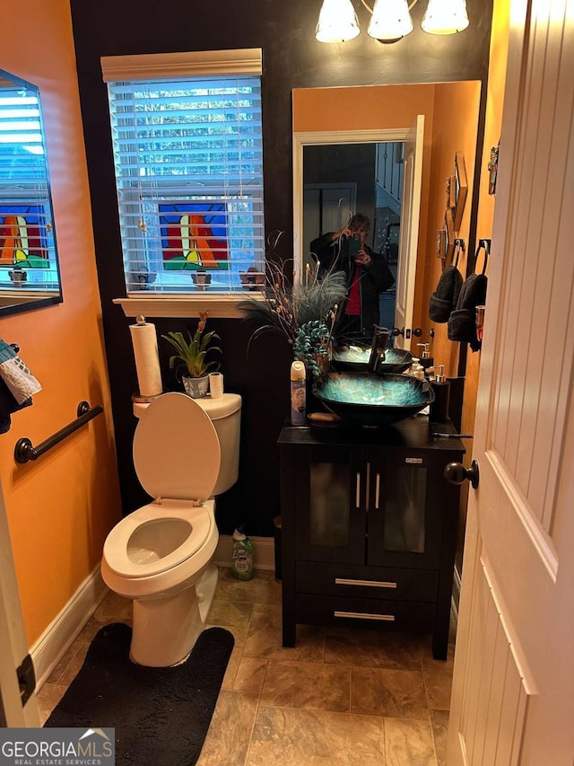 bathroom with baseboards, a sink, and toilet