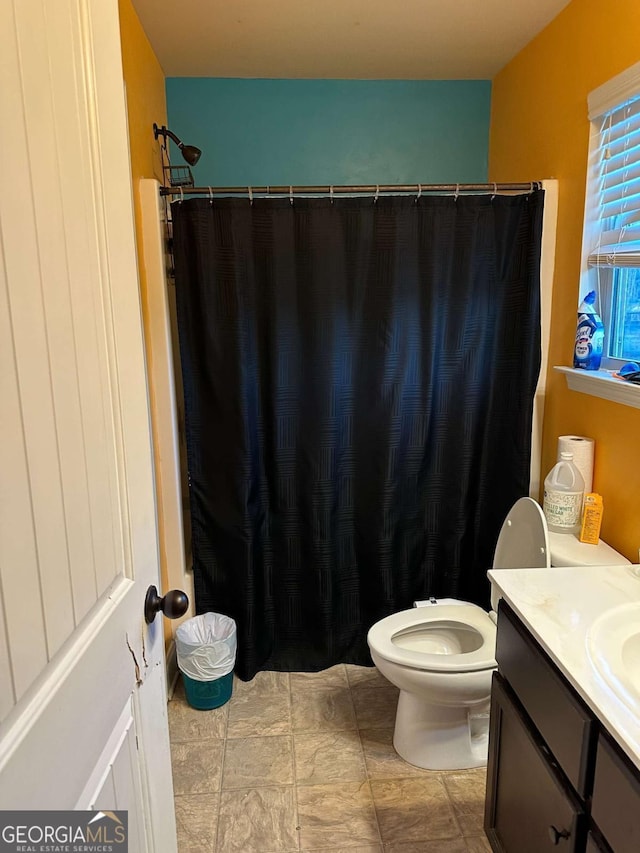 bathroom featuring toilet, a shower with curtain, and vanity