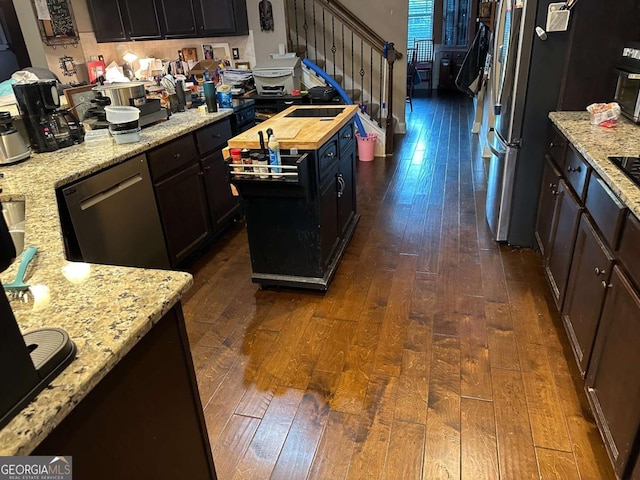 kitchen with dishwashing machine, butcher block countertops, a kitchen island, and dark wood-style floors