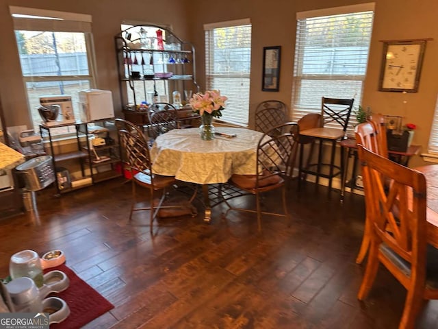 dining area featuring a fireplace and dark wood finished floors