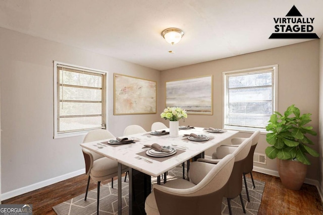 dining area featuring dark wood-style flooring and baseboards