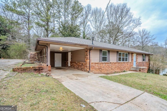 ranch-style house featuring brick siding, roof with shingles, concrete driveway, a front yard, and a carport