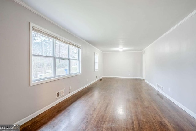 unfurnished room featuring ornamental molding, visible vents, and baseboards