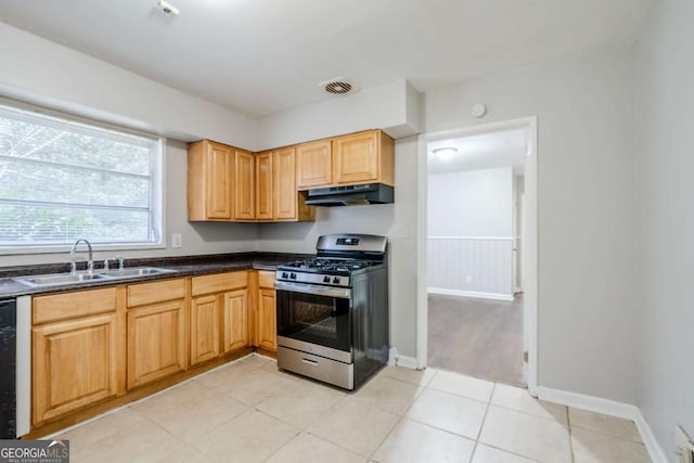 kitchen featuring visible vents, dark countertops, stainless steel gas range, under cabinet range hood, and a sink