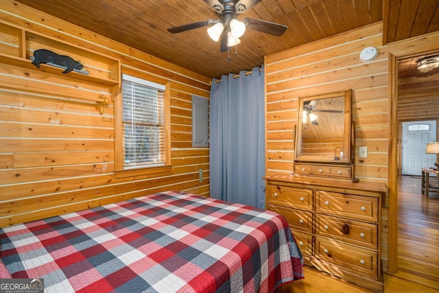 bedroom featuring wood ceiling, wooden walls, ceiling fan, and wood finished floors