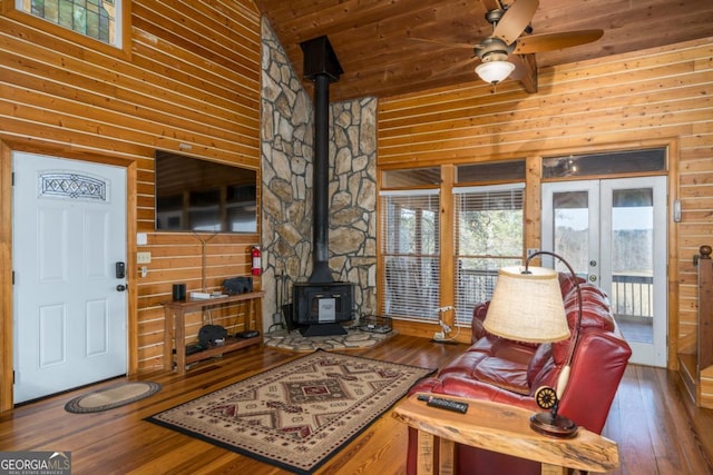 living room with a wood stove, wooden ceiling, dark wood finished floors, and french doors