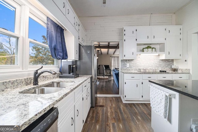 kitchen with open shelves, light stone counters, a sink, and white cabinets