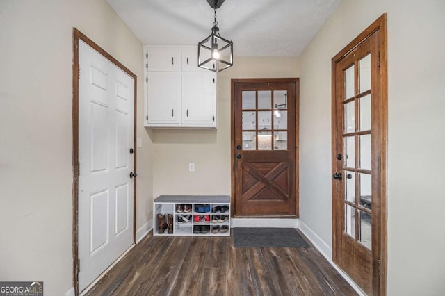 mudroom with dark wood-style flooring and baseboards