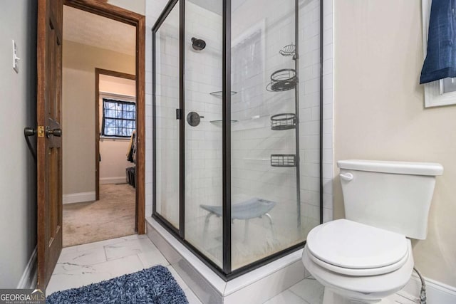 full bathroom featuring marble finish floor, a stall shower, toilet, and baseboards