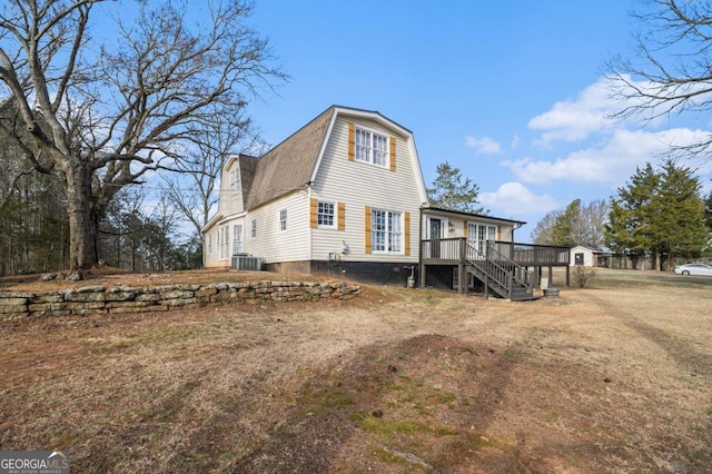 rear view of property featuring central AC, a gambrel roof, a yard, stairway, and a wooden deck