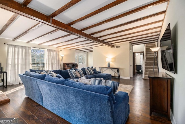 living area featuring baseboards, visible vents, dark wood finished floors, stairway, and beam ceiling