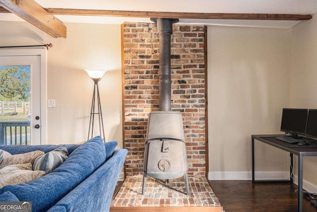 living area featuring a wood stove, baseboards, dark wood-style flooring, and beam ceiling