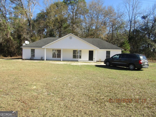 ranch-style home featuring covered porch and a front lawn