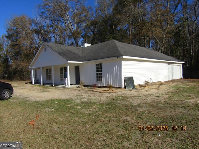 view of front of house featuring a porch, a front yard, and a garage