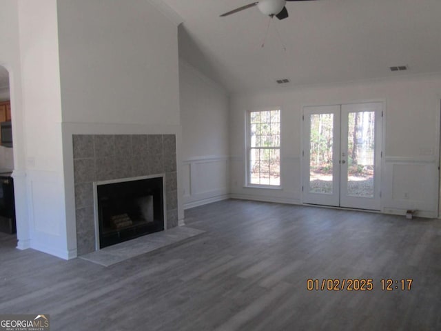 unfurnished living room featuring a wainscoted wall, visible vents, and wood finished floors