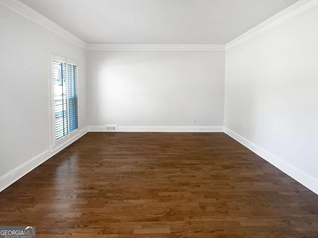 unfurnished room featuring baseboards, dark wood-style flooring, visible vents, and crown molding