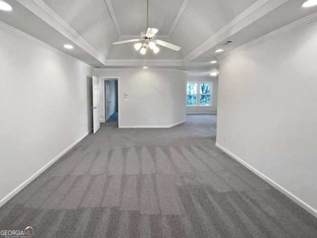 empty room with carpet floors, baseboards, a tray ceiling, and ornamental molding