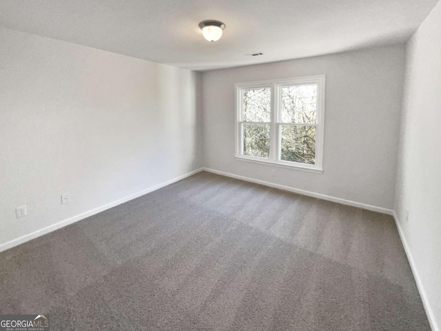 carpeted spare room featuring baseboards