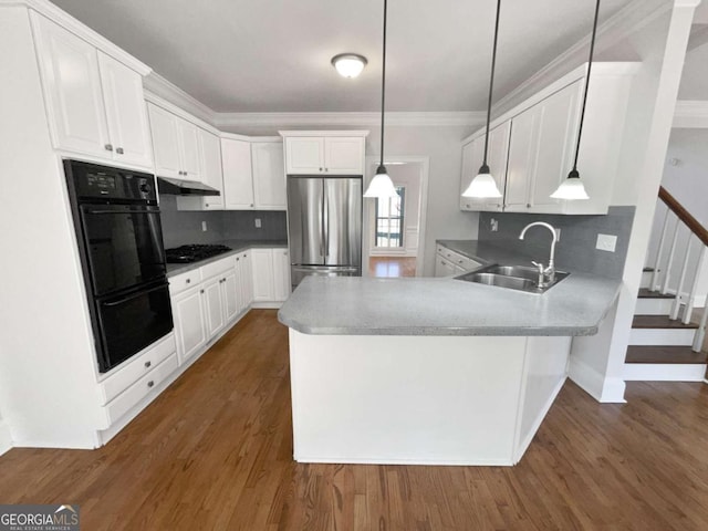 kitchen featuring a peninsula, black appliances, white cabinetry, and a sink