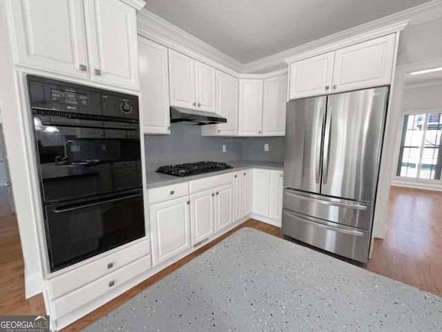 kitchen with black appliances, under cabinet range hood, white cabinetry, and light countertops