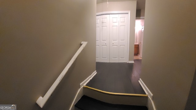 stairway with baseboards and wood finished floors