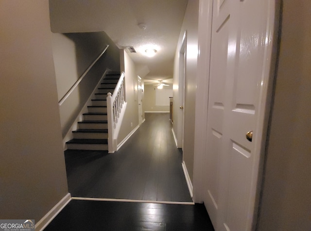 hall with baseboards, visible vents, stairway, and wood finished floors