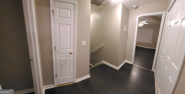 corridor with attic access, baseboards, dark wood-type flooring, and an upstairs landing