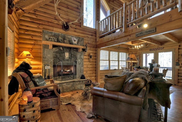 381 Morley Ct, Ellijay, GA 30540 - living room with rustic walls, high vaulted ceiling, wood-type flooring, a stone fireplace, and a chandelier