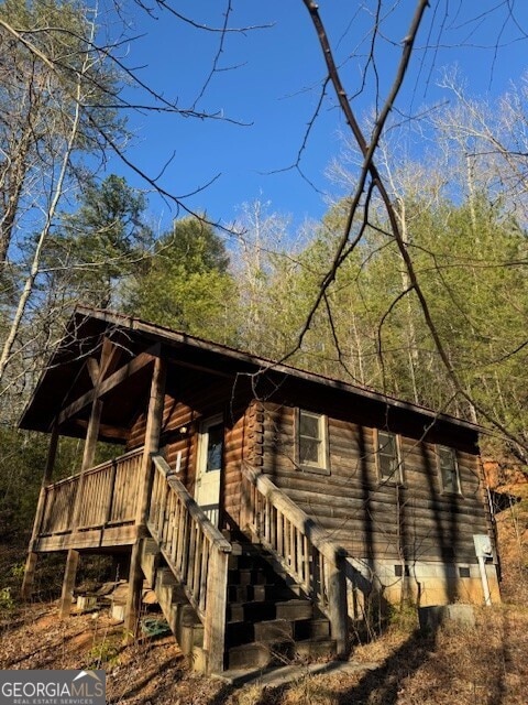 view of home's exterior featuring stairs, crawl space, and log siding