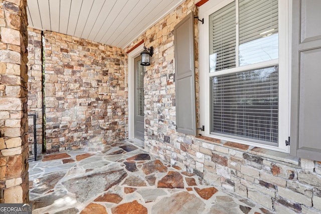 property entrance with stone siding and brick siding