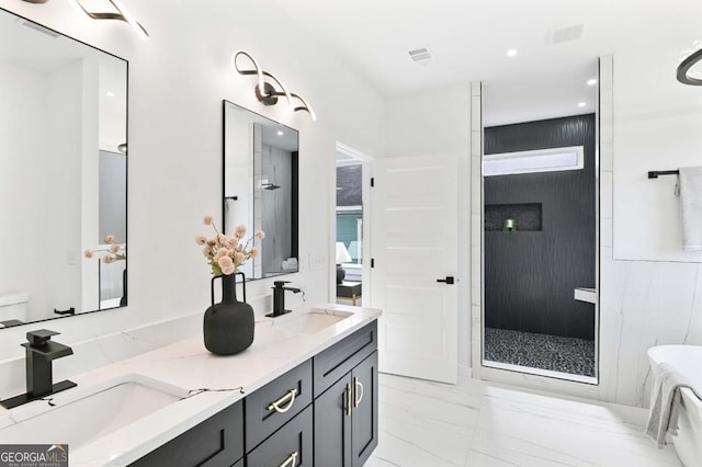 full bathroom featuring marble finish floor, a sink, a tile shower, and double vanity