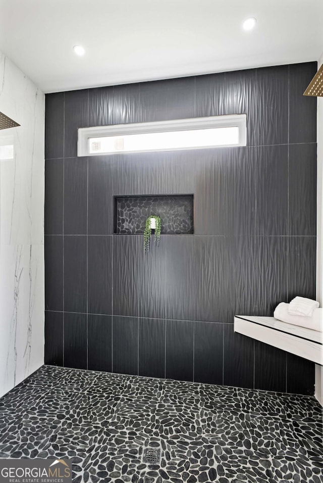 interior details with a tile shower and recessed lighting