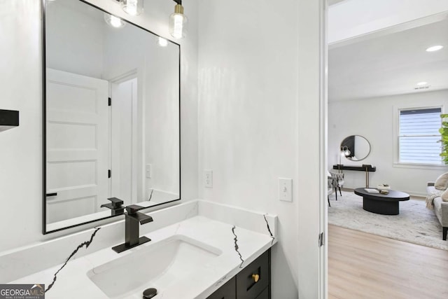 bathroom with wood finished floors, vanity, and recessed lighting