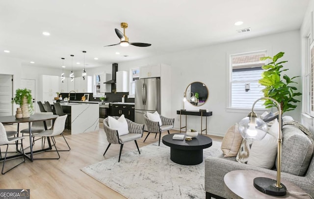 living room featuring light wood-style floors, visible vents, a ceiling fan, and recessed lighting