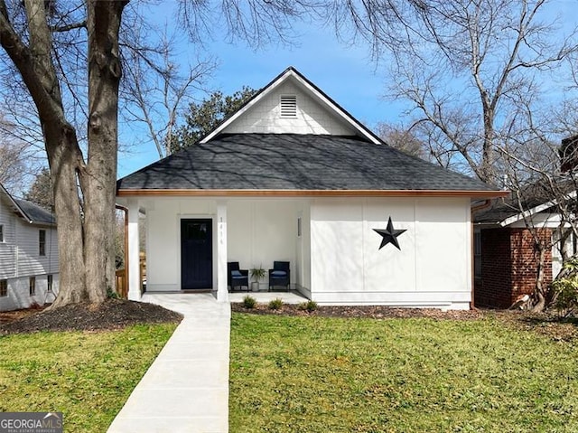 view of front of house featuring roof with shingles and a front lawn