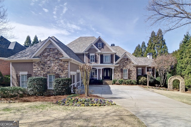 view of front of house featuring stone siding and concrete driveway