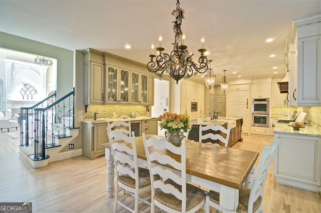 dining room featuring stairway, a notable chandelier, recessed lighting, and light wood-type flooring